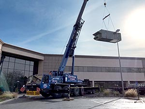 100 ton A/T crane lifting a new air conditioning unit onto the roof of an office building in Westerville, Ohio.